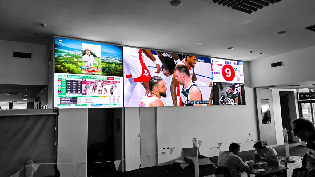 LED screen display in pub showing live sports and entertainment content